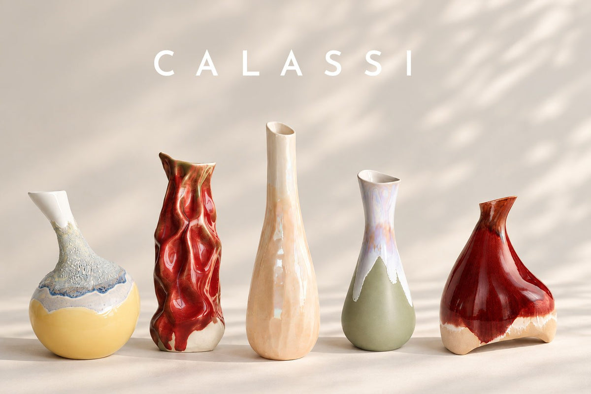 Five Calassi collectible ceramic wine-serving vessels in red, ivory, sage and yellow glazes