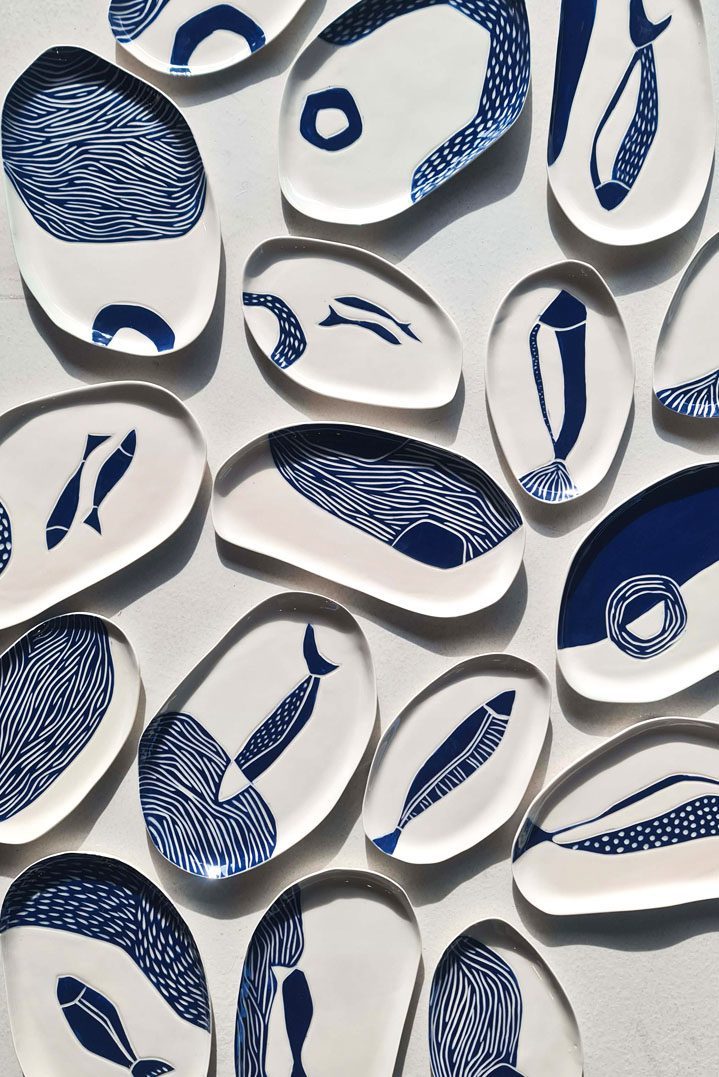 Sgraffito porcelain dishes with hand-carved blue fish and wave patterns on white