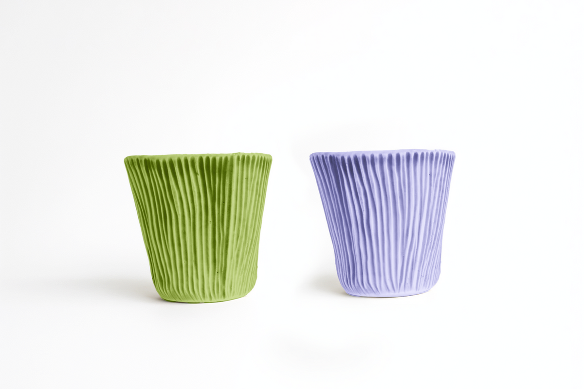 Two small textured ceramic cups in green and lavender glazes