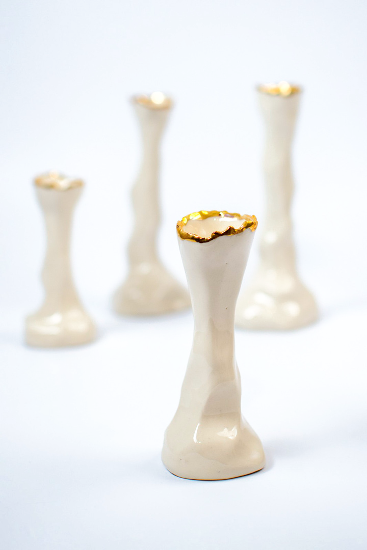 Ivory porcelain candle holders with sculptural stems and gold rims