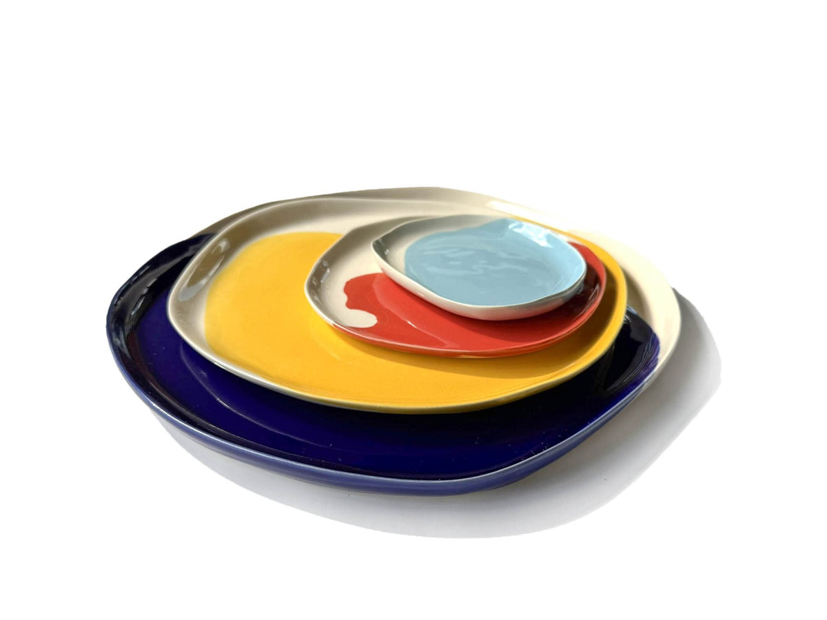 Bauhaus Plates Set stacked: blue, yellow, red and sky blue glazed plates nested together