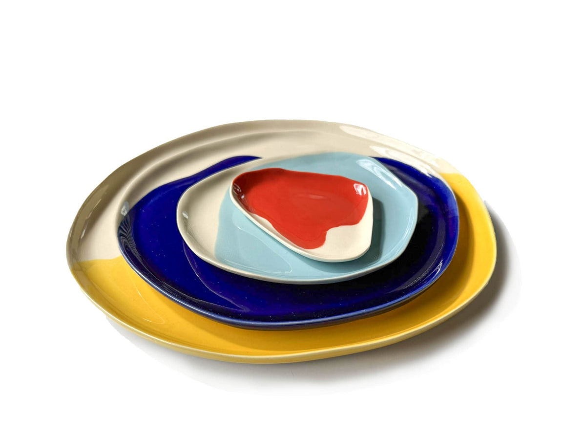 Bauhaus Plates Set 2 stacked in yellow, royal blue, light blue and red glazes on white