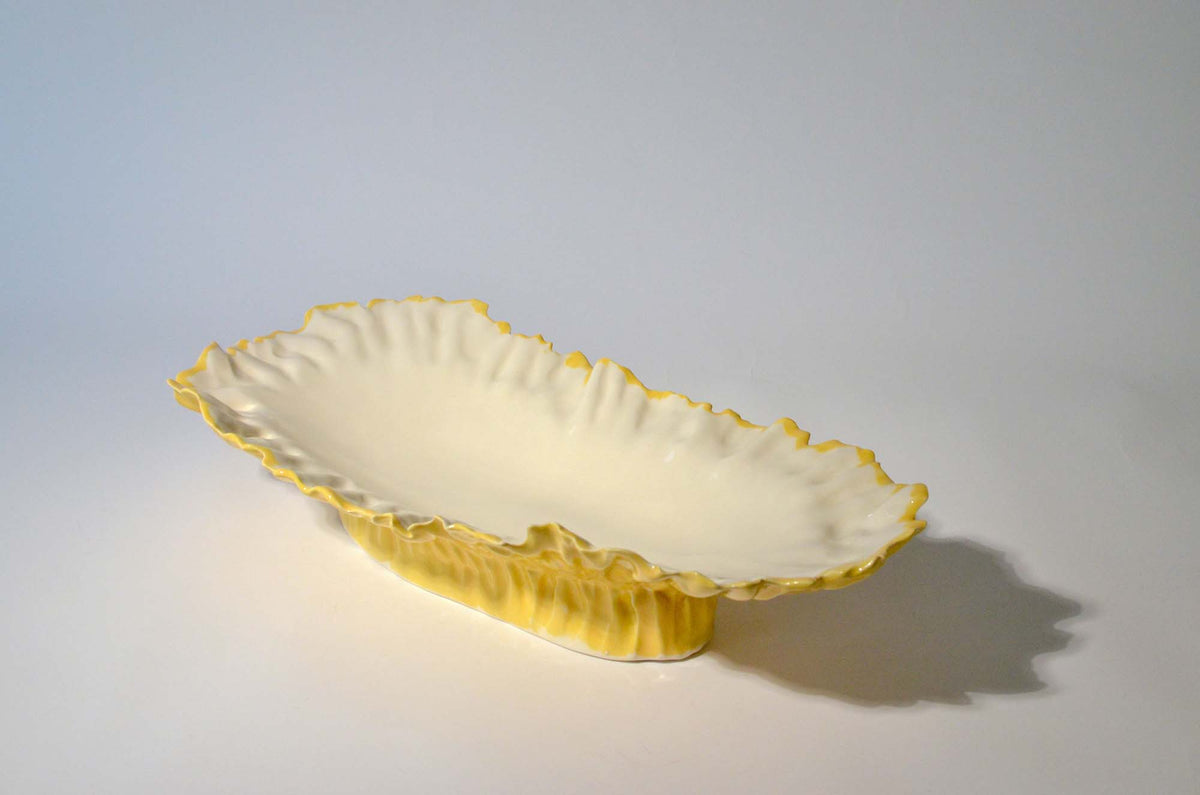 Yellow Blossom elevated serving bowl at an angle on a light background