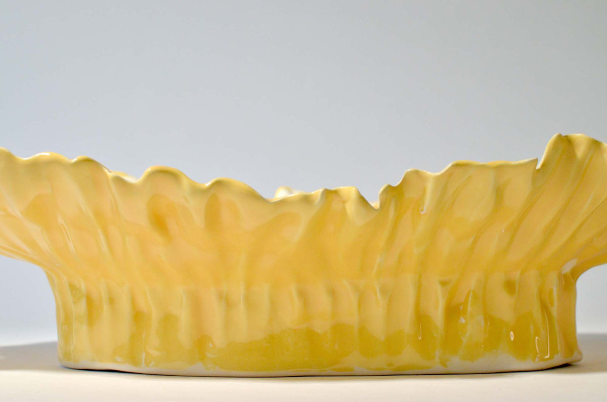 Hand-rippled yellow glazed exterior of the Blossom elevated serving bowl, close side view