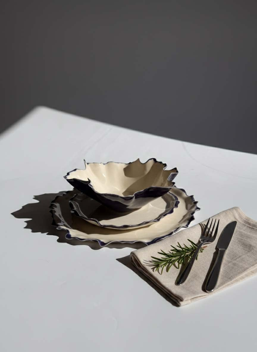 Ivory Blossom plate set with sculptural folded rims on a sunlit table
