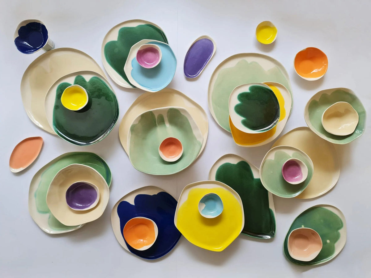 Customizable dining set for 4 in green, blue, yellow and orange glazes, plates and bowls overhead