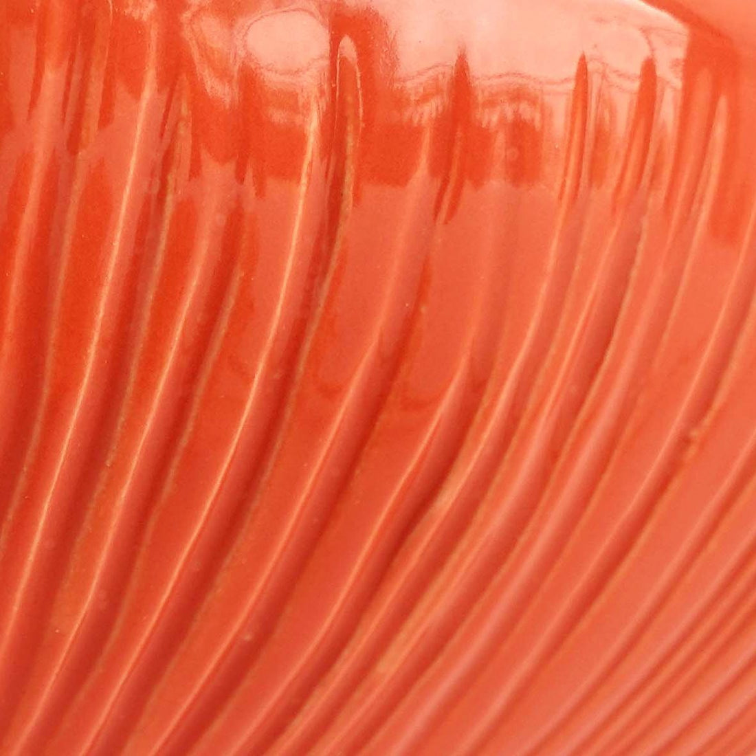 Ferrari Red glaze sample on ribbed textured porcelain, showing the glossy finish over the grooves