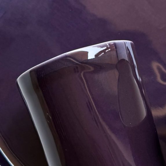 Aubergine glossy glaze sample on a handmade porcelain cup in deep purple