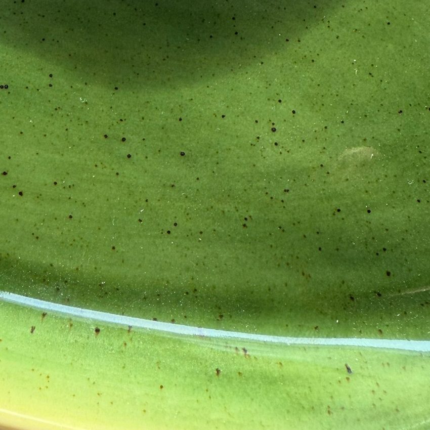 Kiwi Green glossy glaze sample on handmade porcelain with fine brown speckles