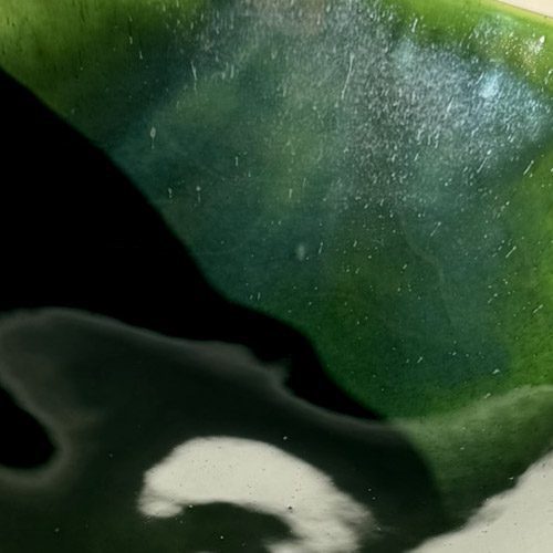 Moss Green glossy glaze sample on handmade porcelain with deep pooling and a white edge