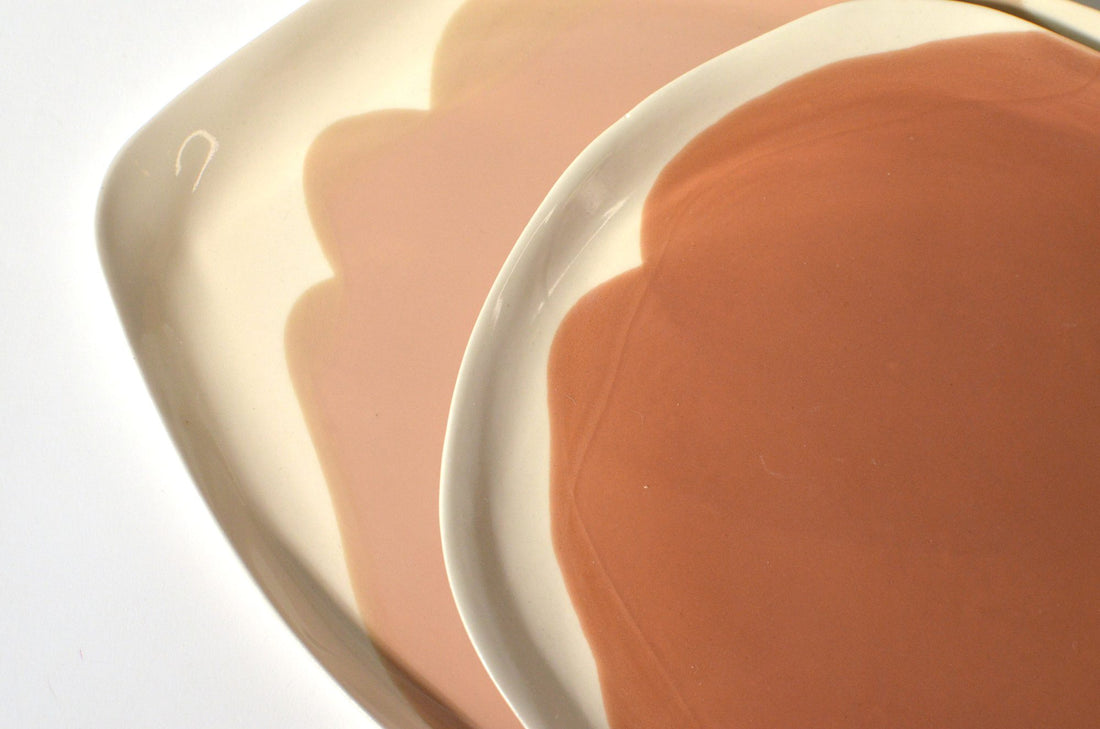 Close-up of handmade porcelain plates in Hazelnut glaze with scalloped white edges