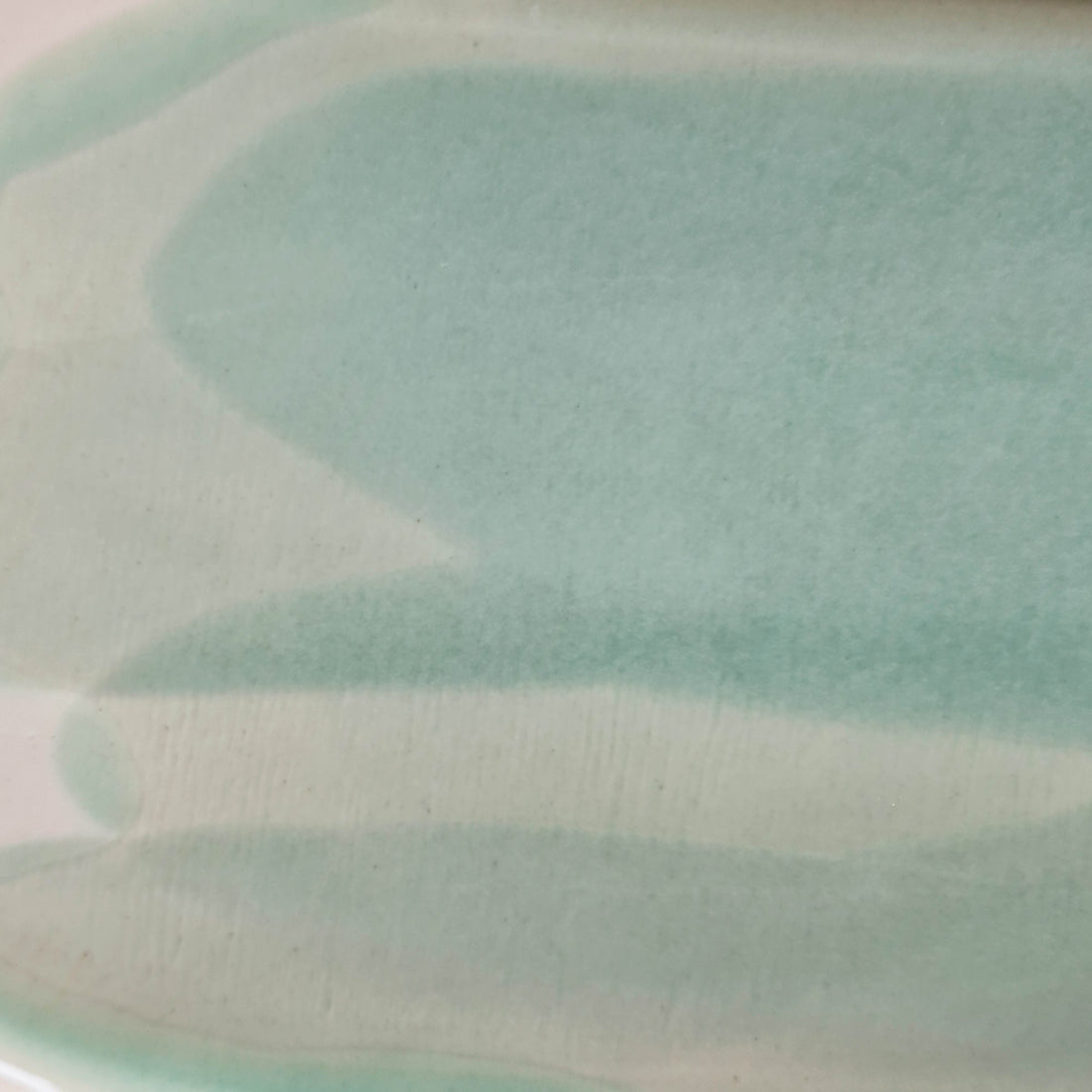 Close-up of Sage Green glaze brushstrokes on handmade porcelain showing the soft matte finish
