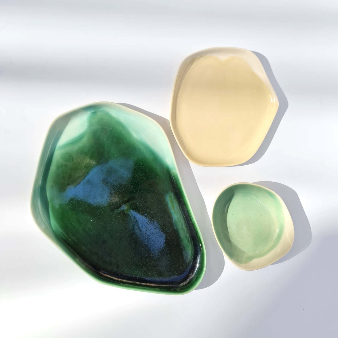 Organic-shaped porcelain dishes in Forest Green, butter yellow and mint glaze from above