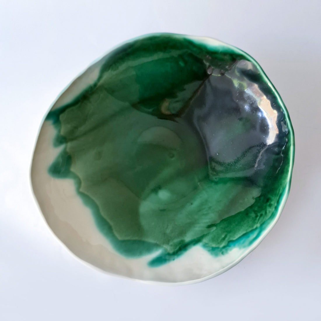 Handmade porcelain bowl with a pooled, glossy Forest Green glaze over a white clay body