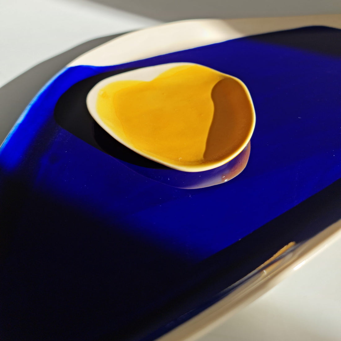 Royal Blue glazed porcelain platter holding a small yellow ceramic dish with a white rim