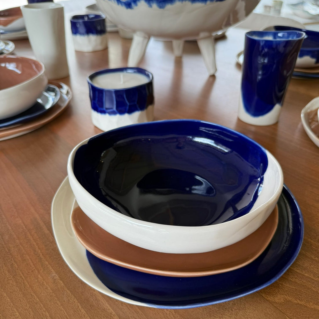 Table set with Royal Blue glazed ceramic bowls, terracotta plates and handmade porcelain cups