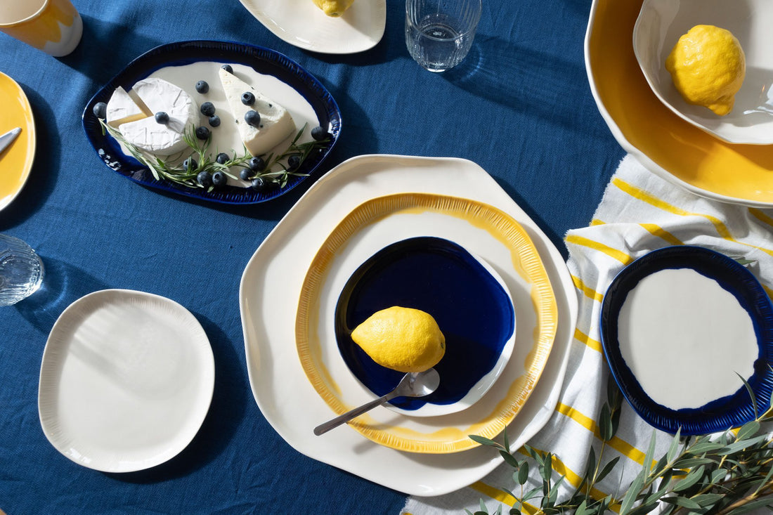 Summer table with Royal Blue and yellow handmade porcelain plates, lemons and a dessert