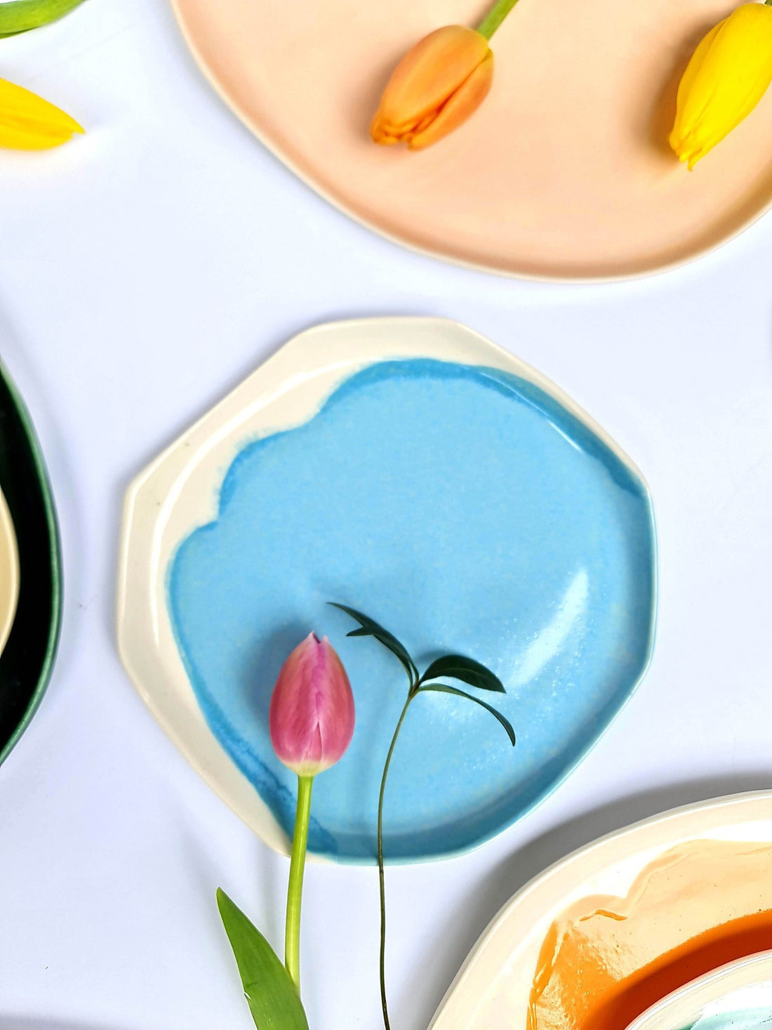 Sky Blue handmade porcelain plate with a scalloped rim and a pink tulip, among pastel plates