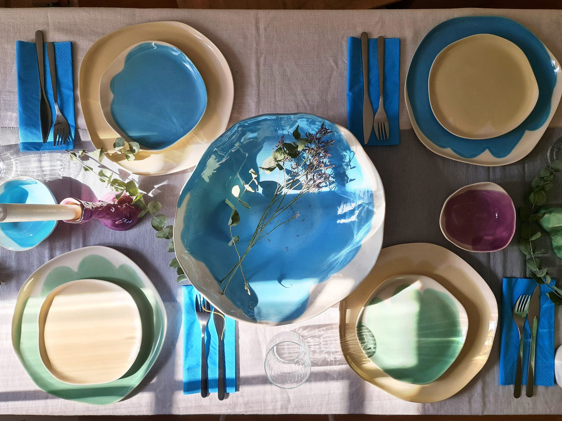 Dinner table from above set with Sky Blue and blue handmade ceramic plates and blue cutlery