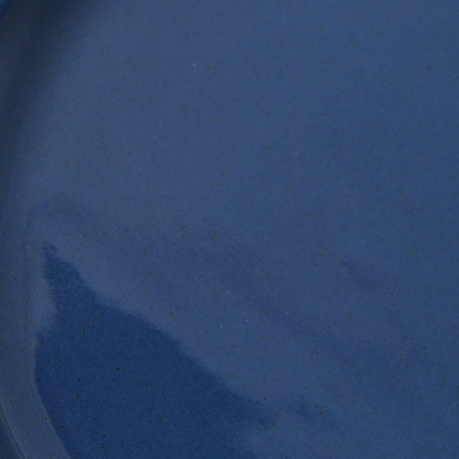 Close-up of Dark Denim glossy glaze sample on handmade porcelain
