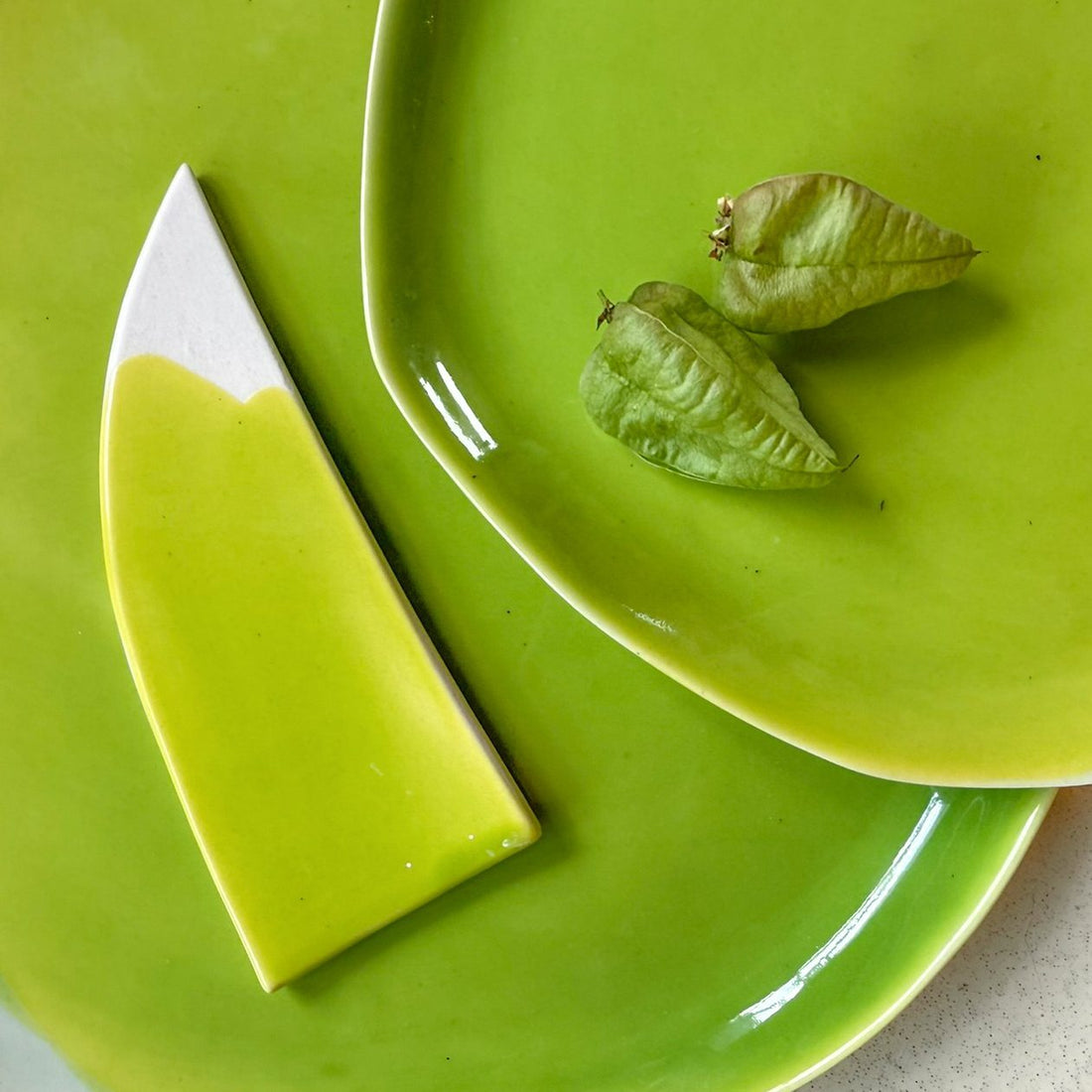 Electric Matcha glazed porcelain plate and pointed serving board with a white dipped edge