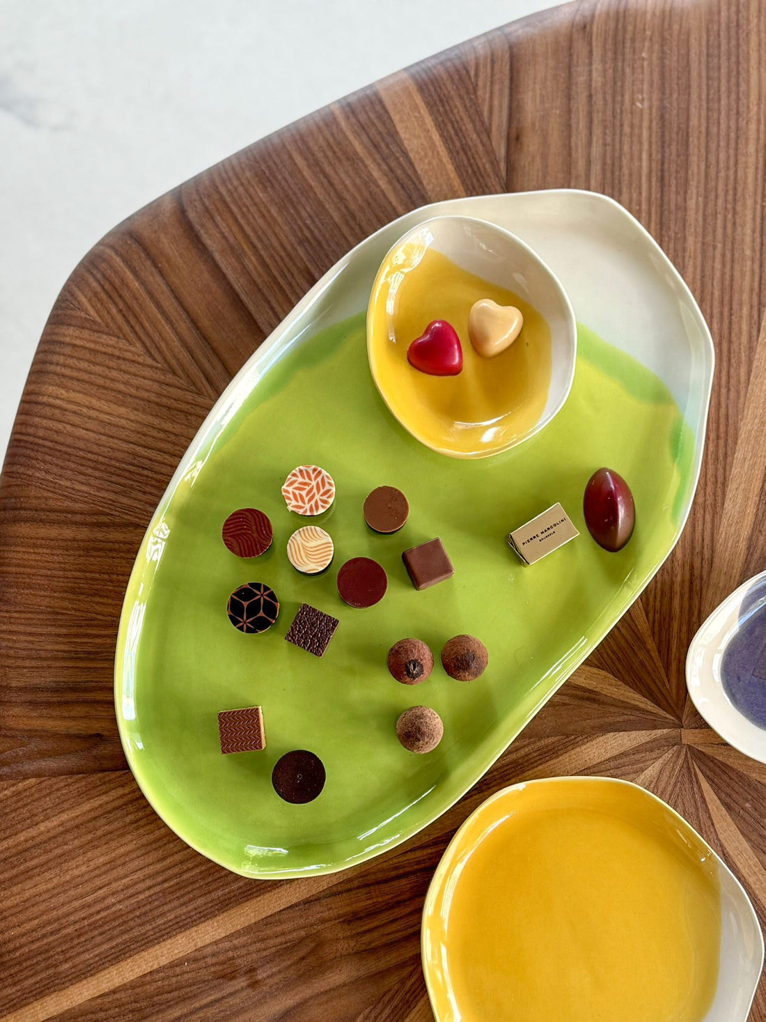 Electric Matcha oval porcelain serving tray with chocolates, a small yellow bowl and a matching plate