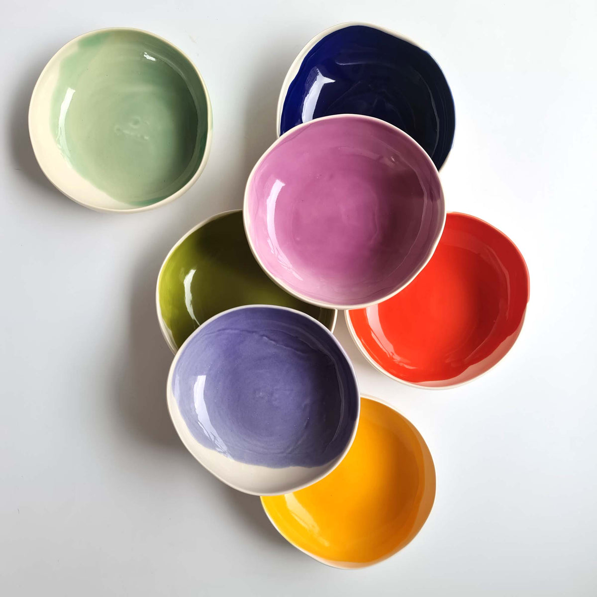 Round handmade bowls in green, blue, pink, red, lavender and yellow glazes