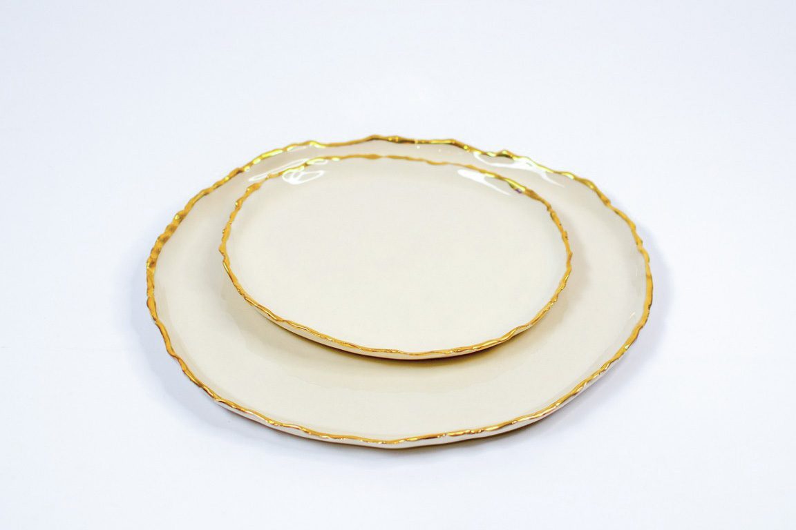 Stacked ivory Gilded Ridges side and dinner plates with irregular gold rims