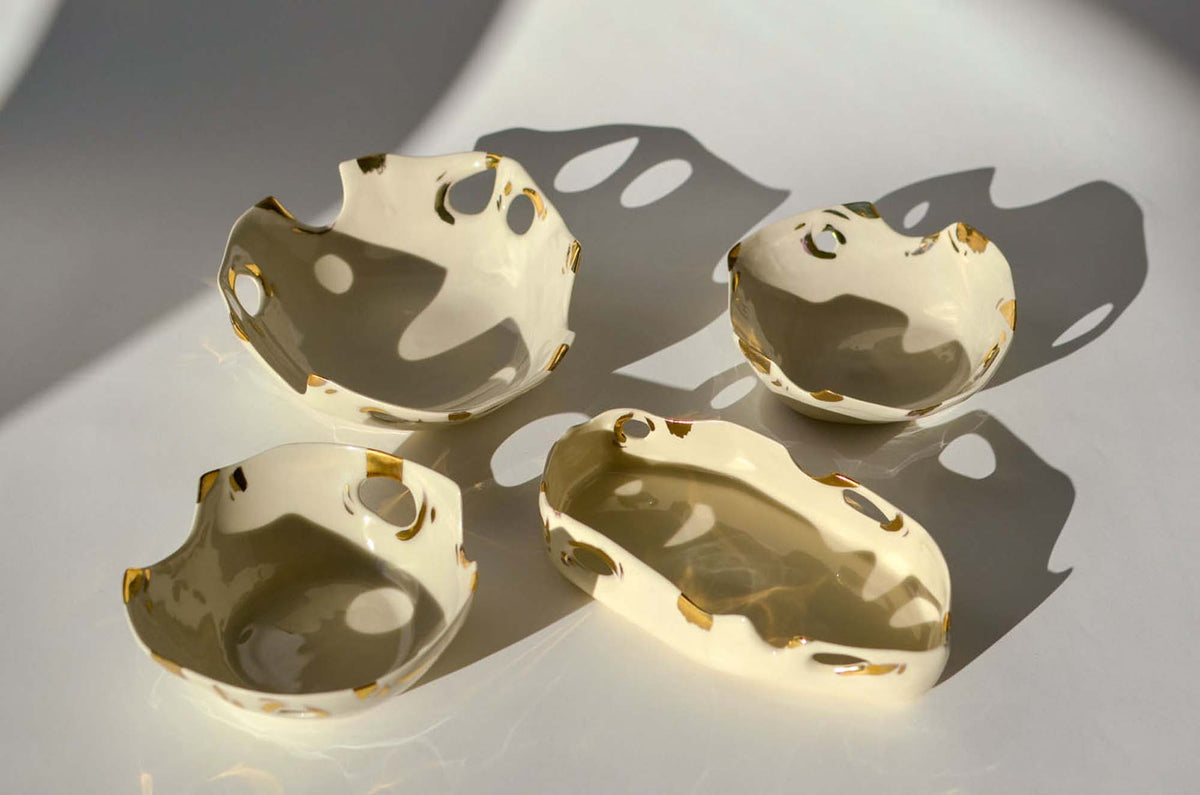 Four small Laced collection porcelain dishes with cut-out edges and gold lace details