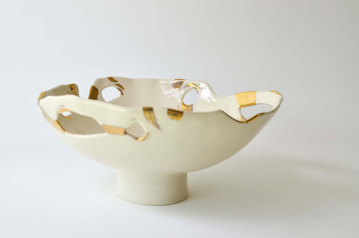 Footed porcelain bowl from the Laced collection with a pierced rim and gold lace accents
