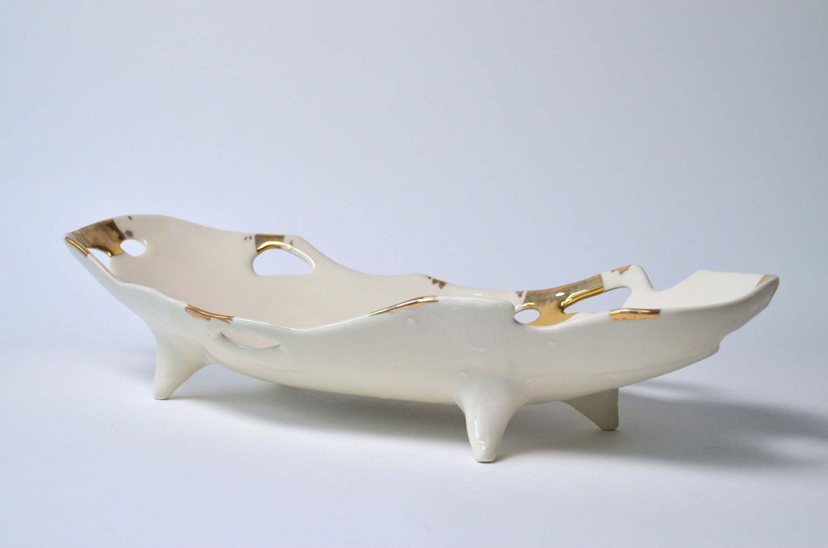 Footed white porcelain serving dish from the Laced collection with cut-out openings and gold lace accents
