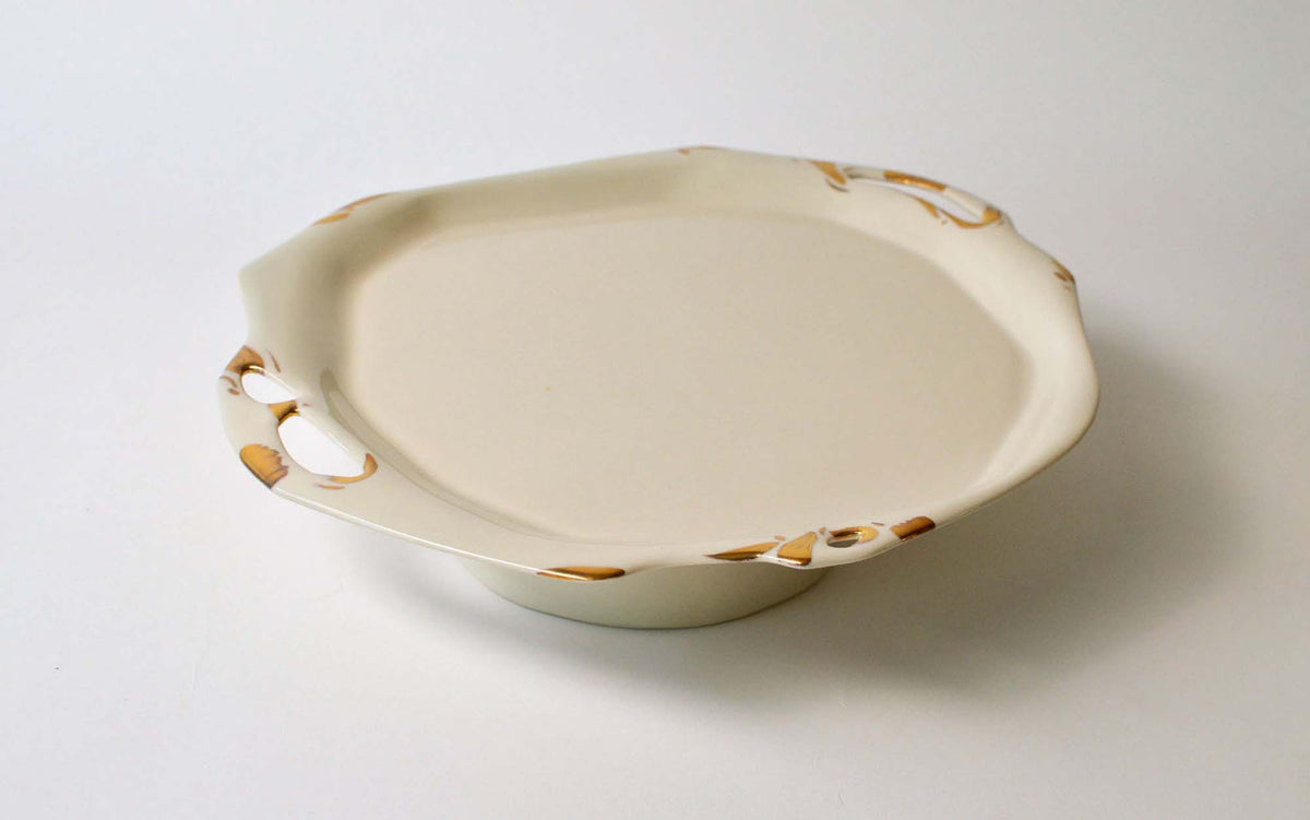 Low porcelain plate from the Laced collection with a cut-out rim and gold detailing