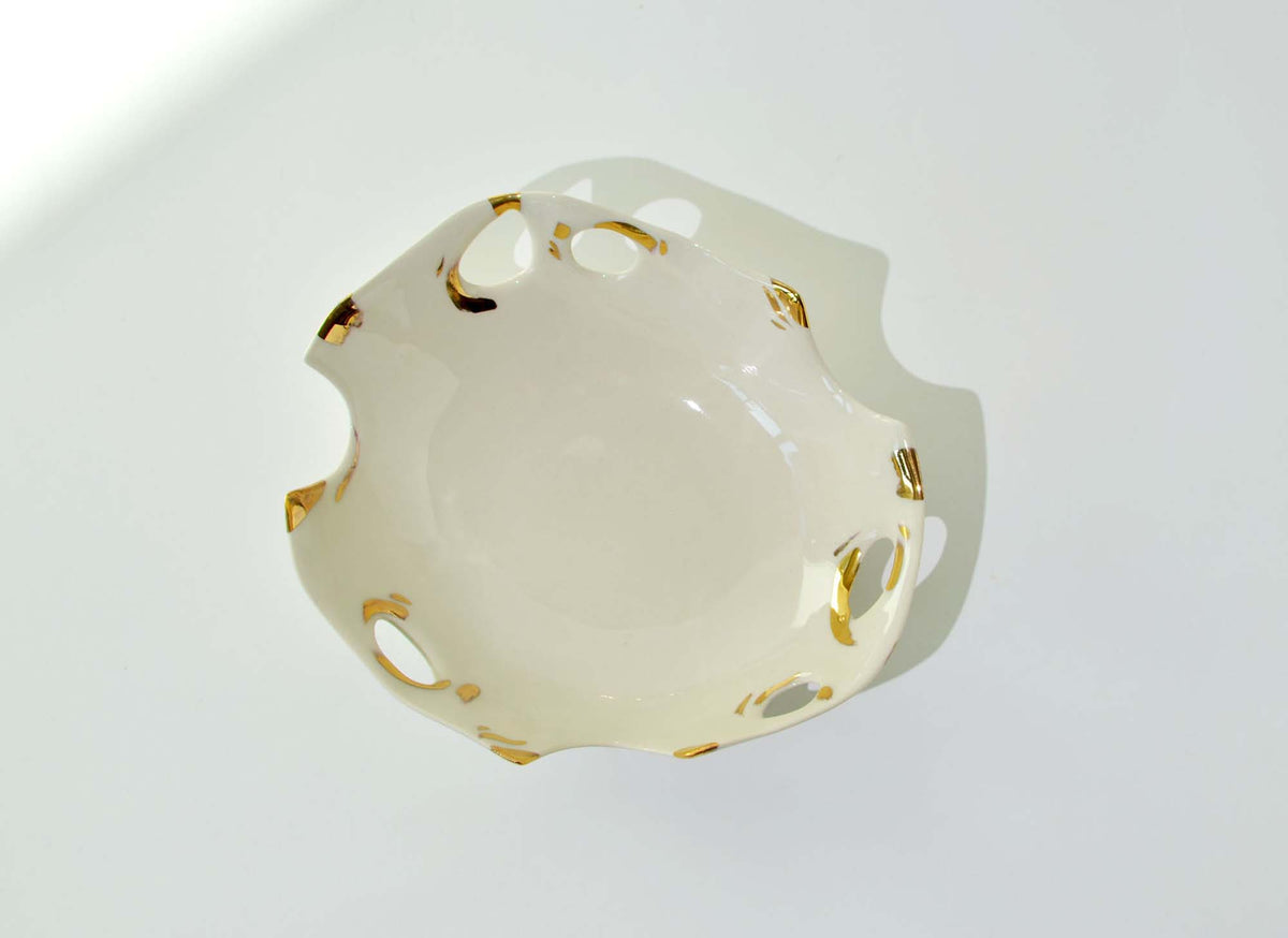 Laced porcelain bowl seen from above, its openwork rim edged in gold