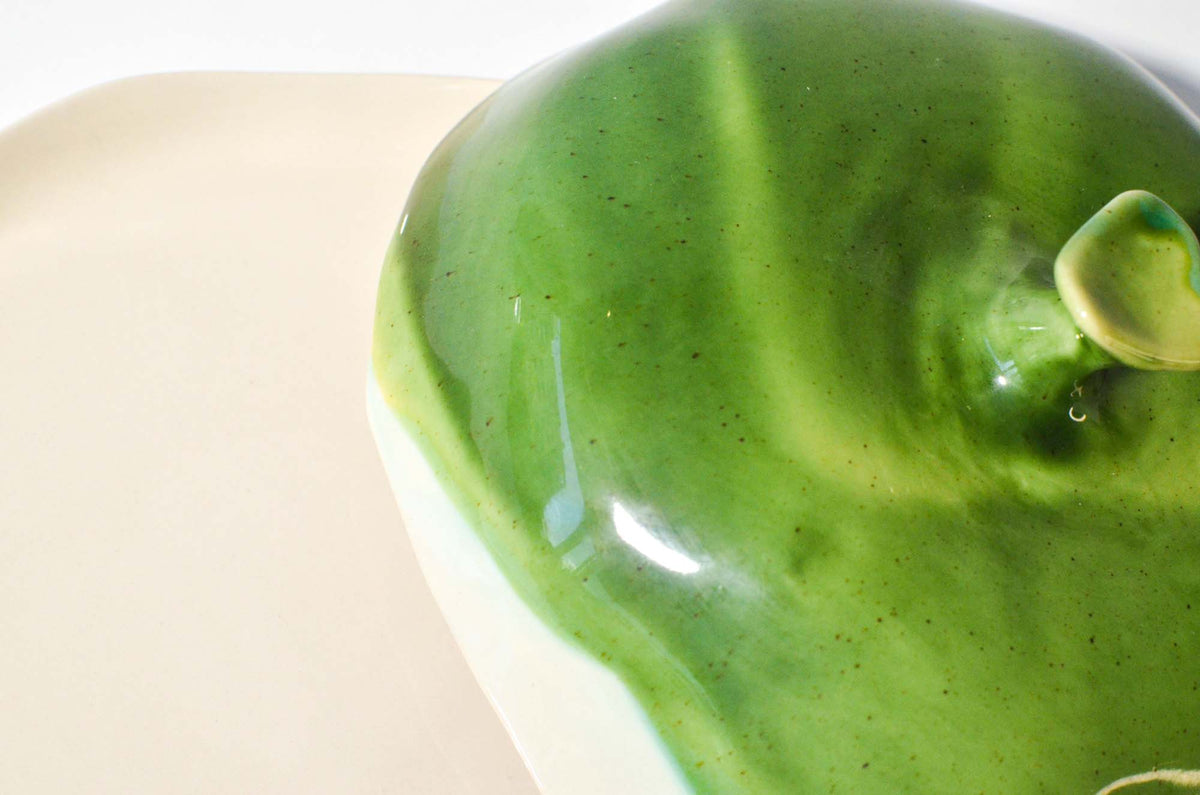 Close-up of the green glazed lid and handle of a handmade ceramic cheese box