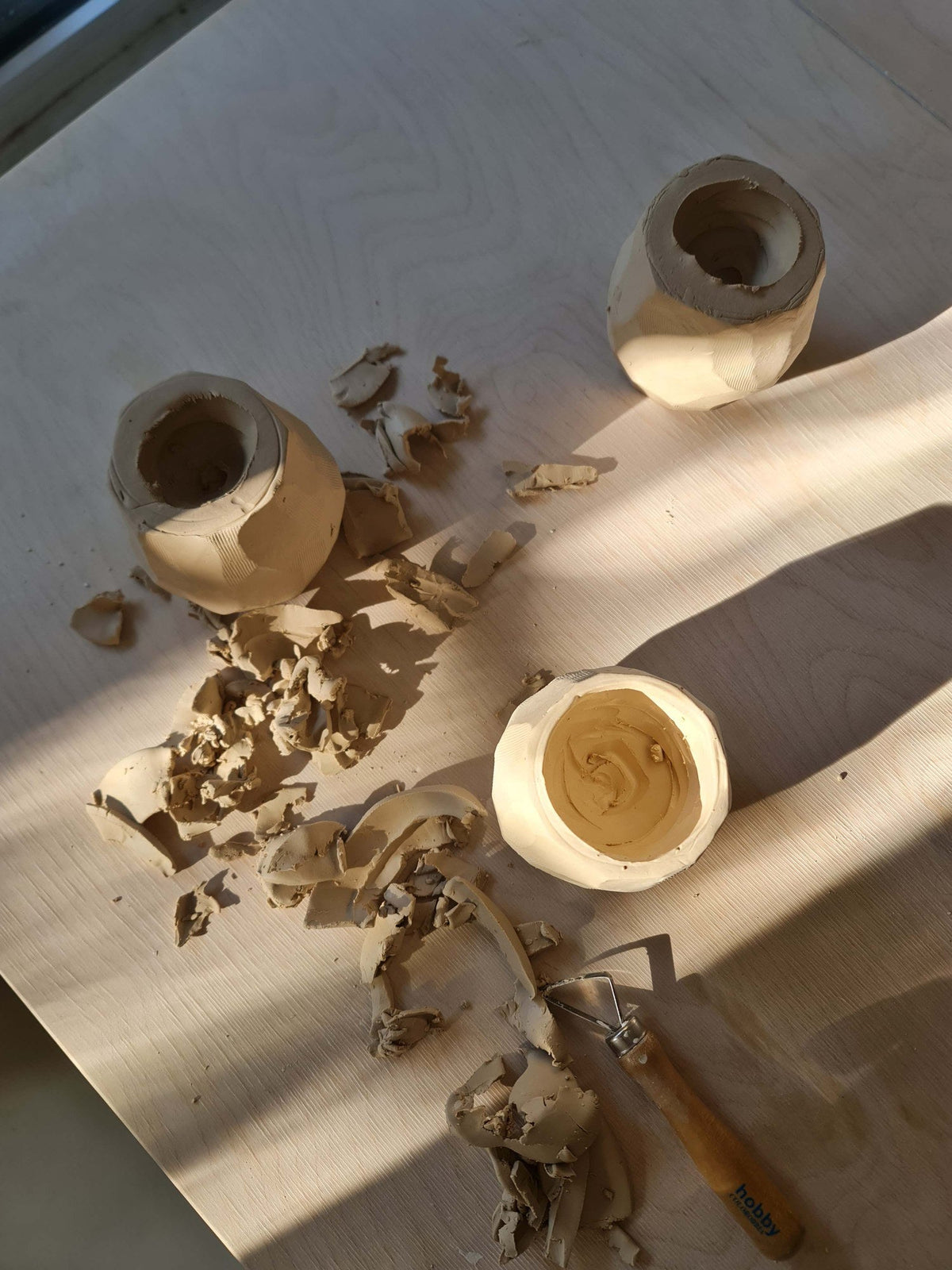 Carving a kurinuki cup from a solid block of clay, with clay shavings