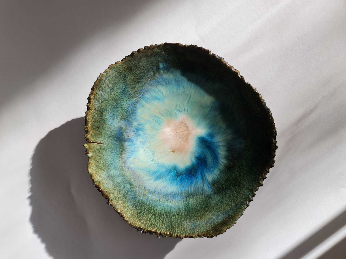 Legged Plate from Black Clay in green and turquoise glaze with a pale centre, seen from above