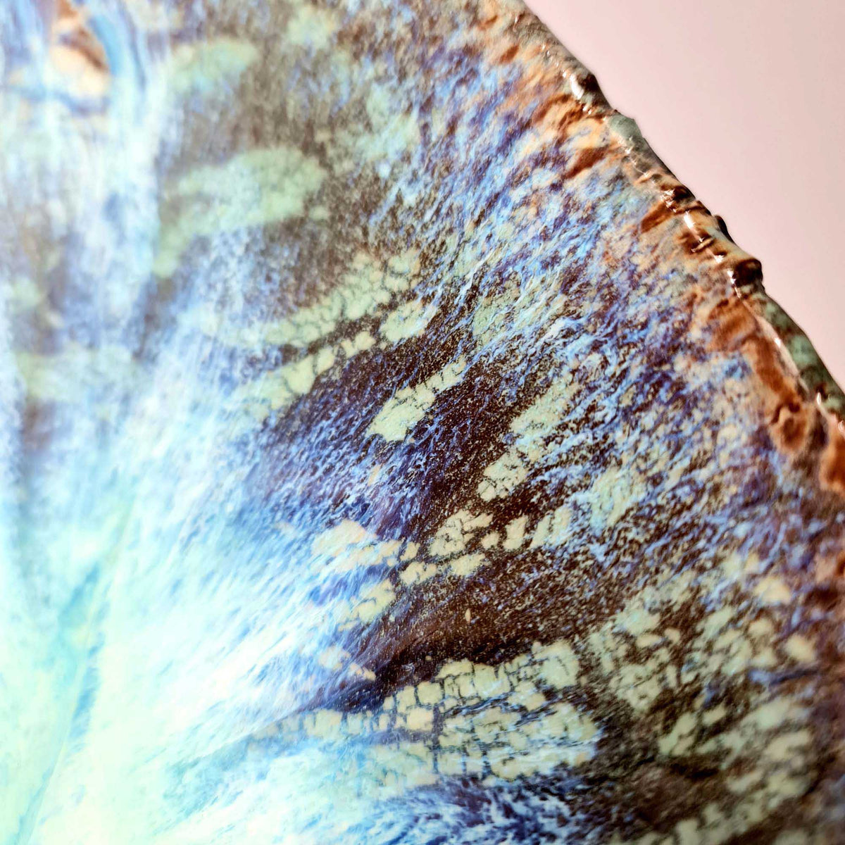 Macro detail of crackled blue, cream and brown reactive glaze on the Legged Plate from Black Clay