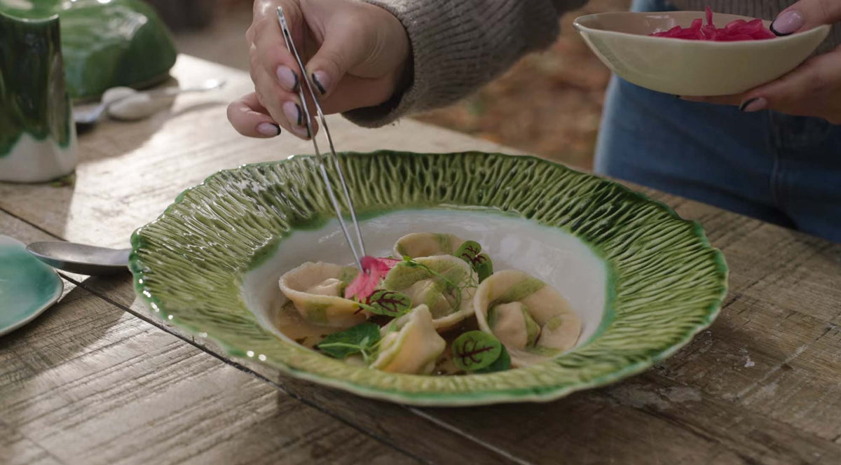 Plating tortellini in the deep porcelain plate for Materia Mensa episode 4