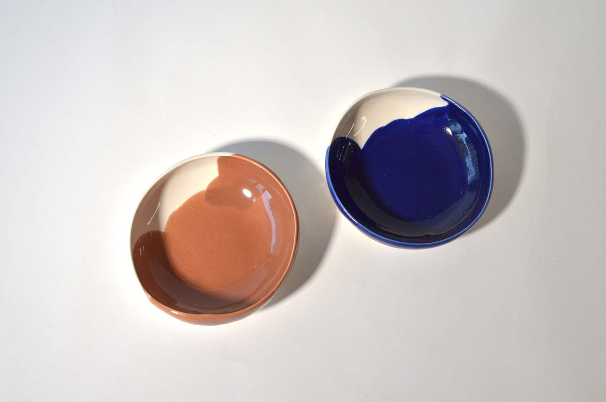 Two round handmade bowls with terracotta and royal-blue interiors