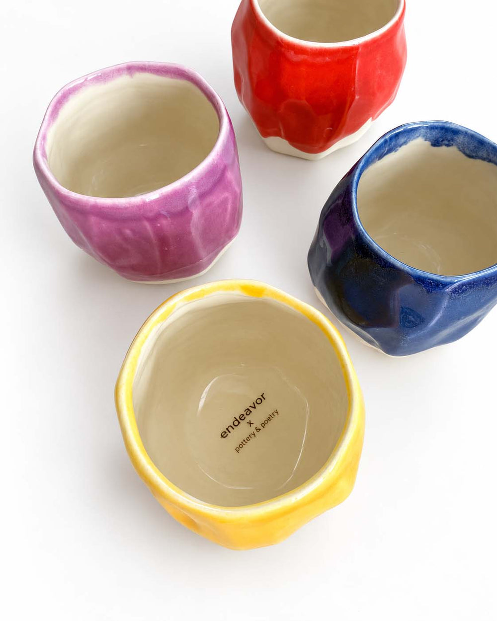 Personalised handmade porcelain cups in pink, red, blue and yellow glaze with a custom stamp inside