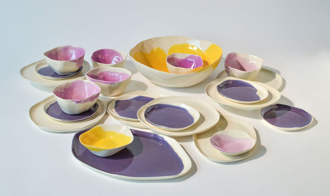 Customizable dining set for 4 in lavender, pink and yellow glazes, plates and bowls laid out