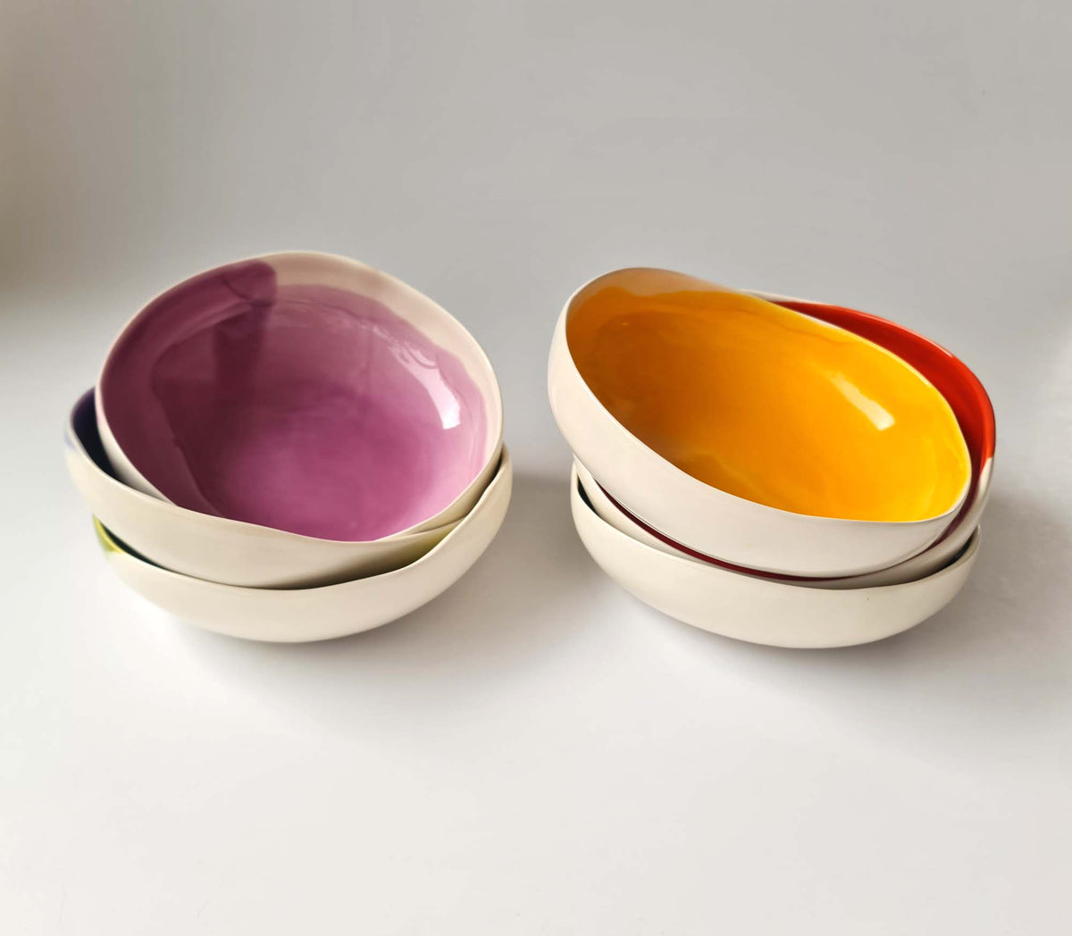 Pairs of small round ceramic bowls with plum and yellow glazed interiors