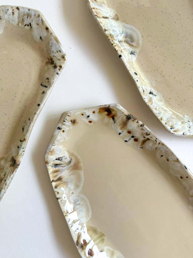 Close-up of the glazed rim of the Salon plates in cream, amber and brown