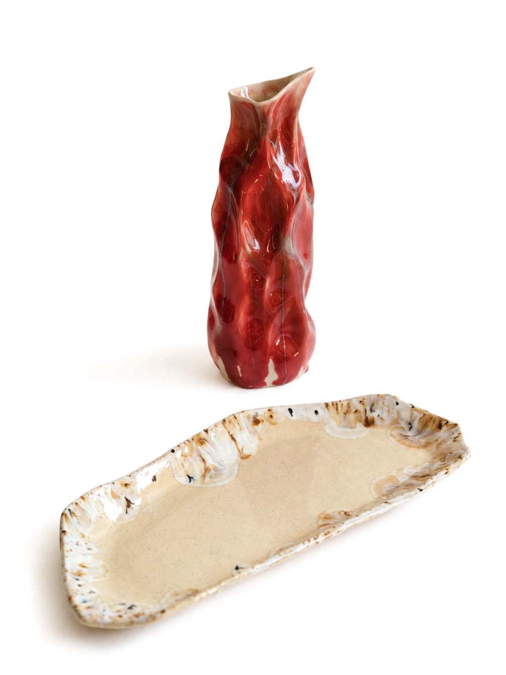Salon plate in sandy clay next to a red glazed vase