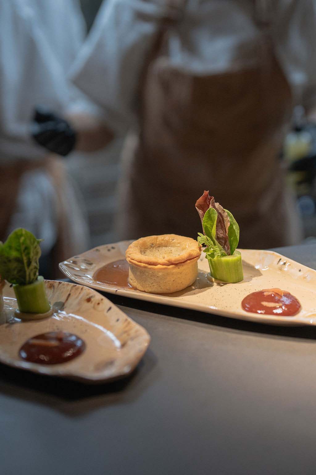 Plated course on the Salon plate: pie, sauce and cucumber with herbs