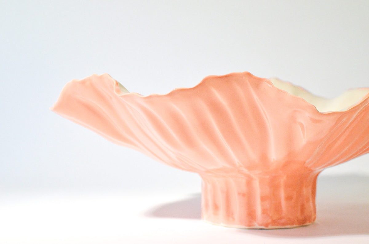 Pink sculptural serving bowl with a flared rim and a ribbed pedestal