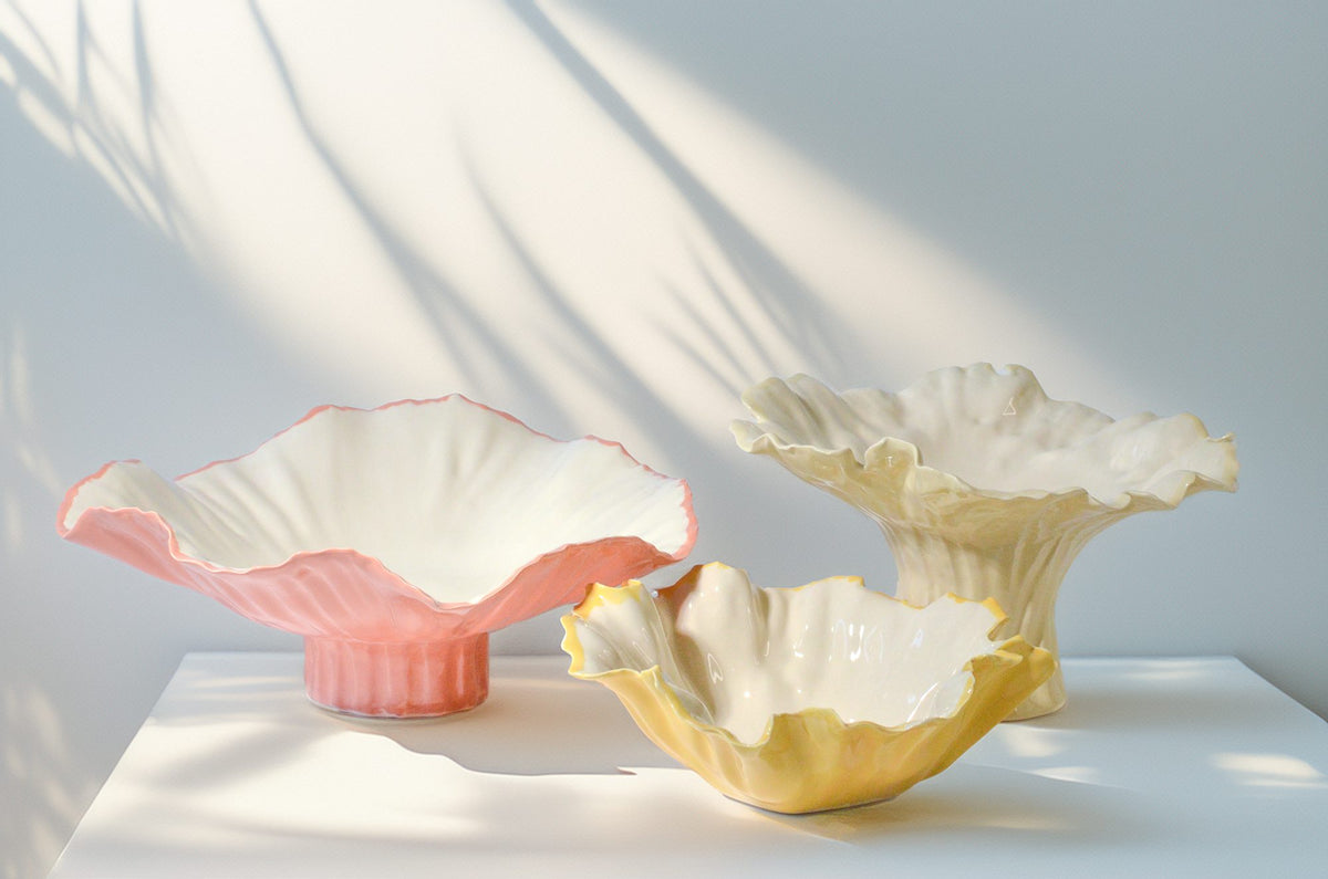 Sculptural pedestal bowls in pink, ivory and yellow glazes