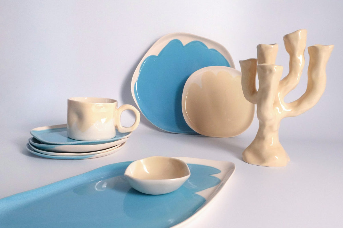 Blue and ivory ceramic tableware with a mug, vase and sculptural candle holder