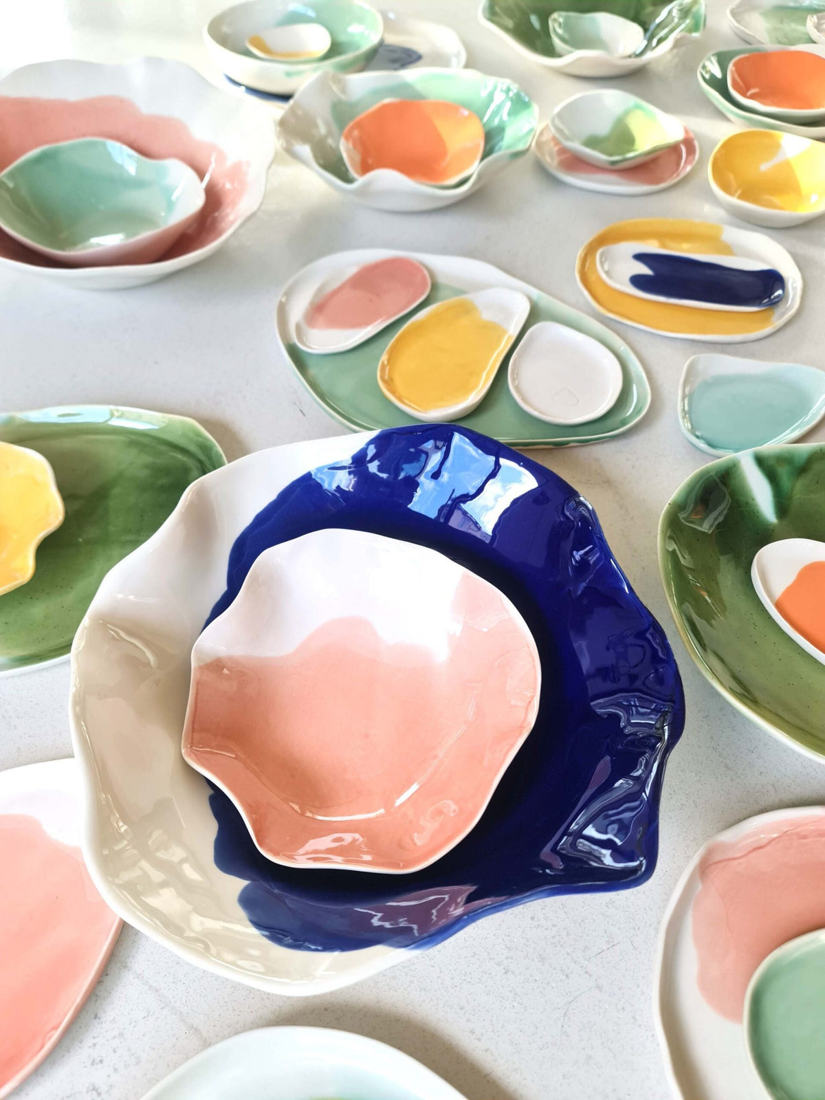 Colourful glazed porcelain plates and bowls made during a short porcelain course