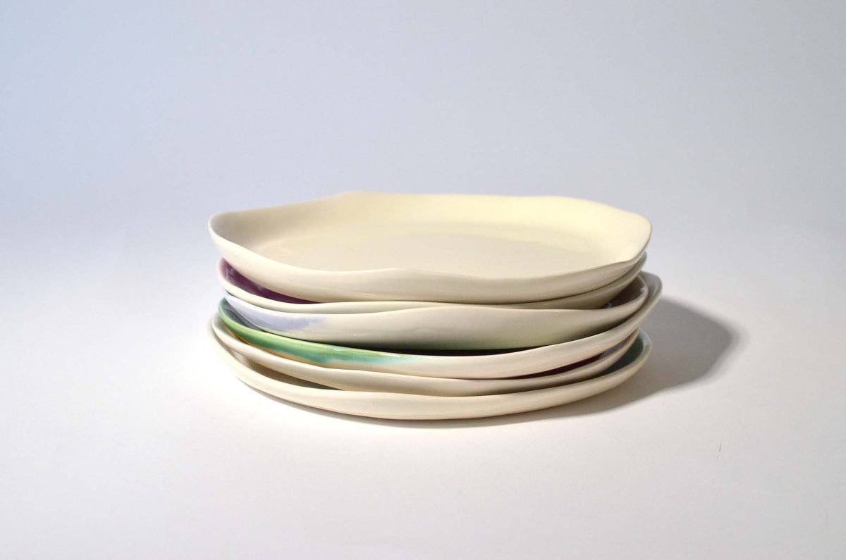 Stacked ivory side plates with irregular edges and coloured rims